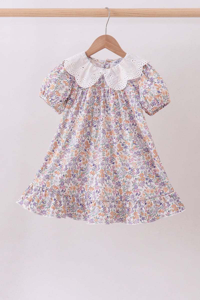 Floral dress with a lace collar on a hanger against a plain background Aaria Tees