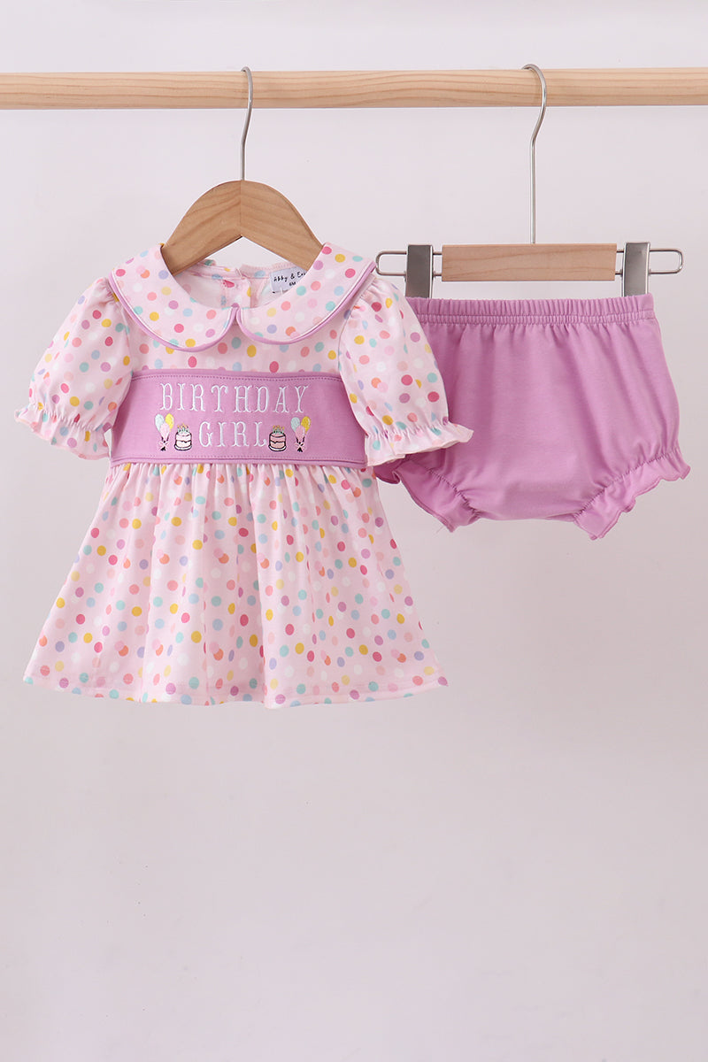 Baby girl's outfit with polka dot dress and pink bloomers on a hanger against a white background Aaria Tees