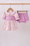 Baby girl's outfit with polka dot dress and pink bloomers on a hanger against a white background Aaria Tees