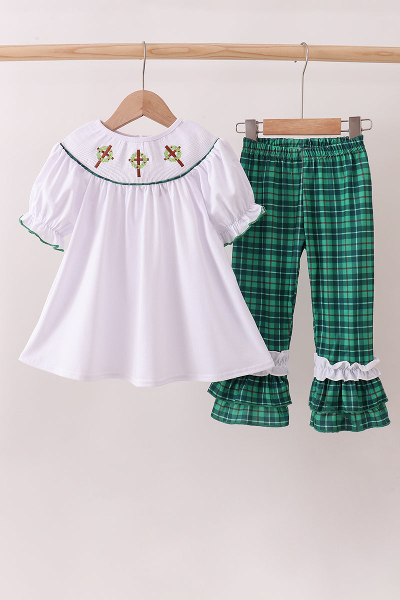 White top with embroidered details and green plaid pants on hangers against a white background Aaria Tees