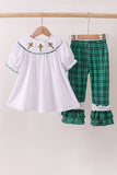White top with embroidered details and green plaid pants on hangers against a white background Aaria Tees
