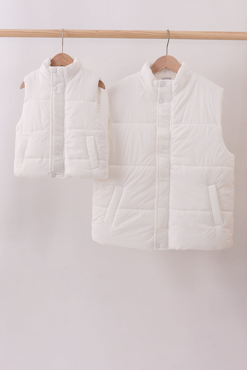 Two white puffer vests hanging on wooden hangers against a white background Aaria Tees