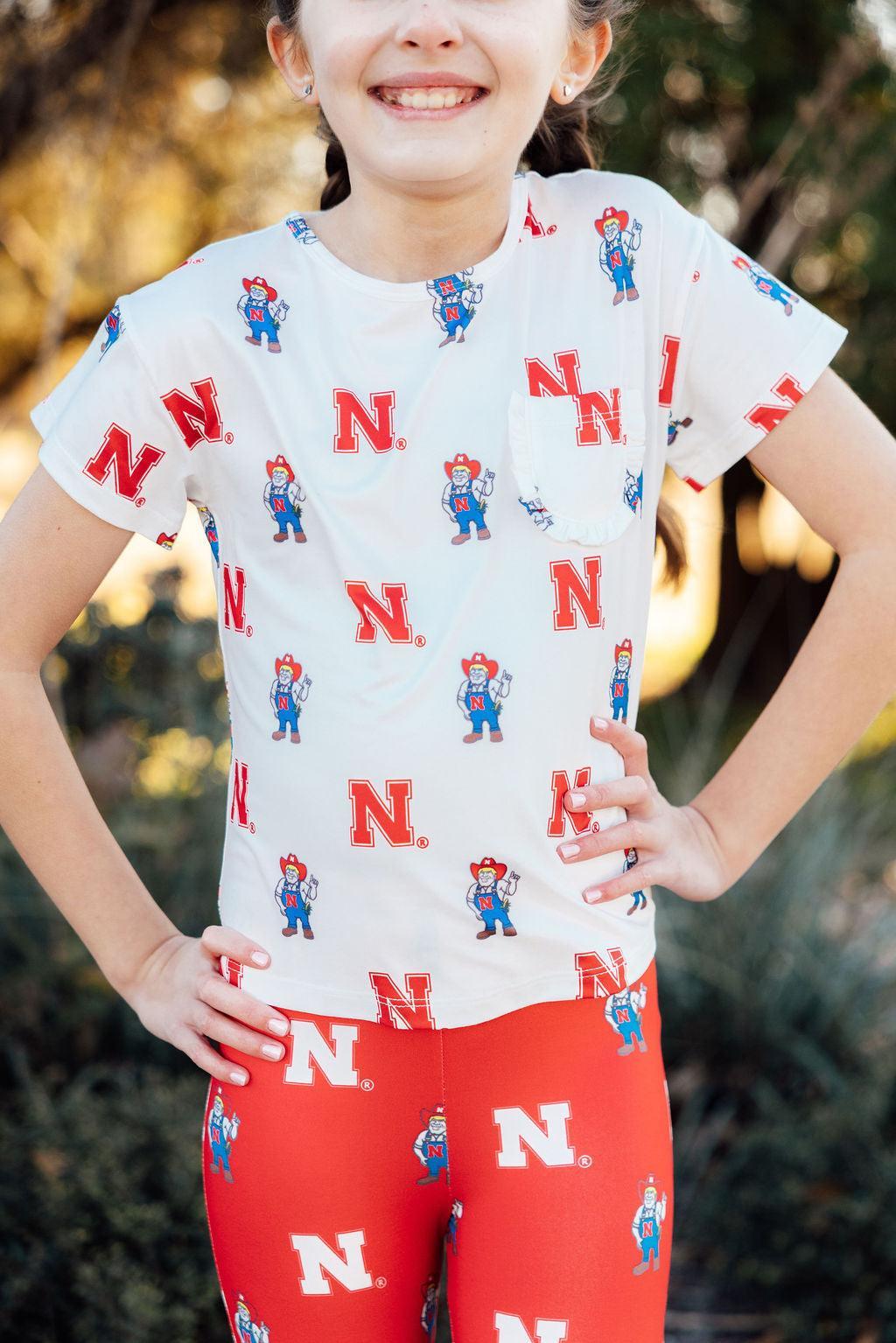 Nebraska White Herbie Husker Ruffle Pocket Tee - Aaria Tees Aaria Tees